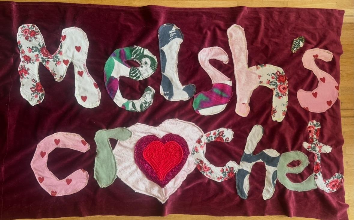 Melsh's Crochet market stall with the hand-stitched banner and crochet pieces